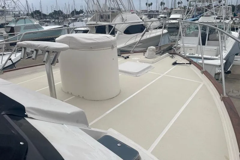 1990 Offshore Yachts 55 Pilothouse deck view in marina with surrounding boats.