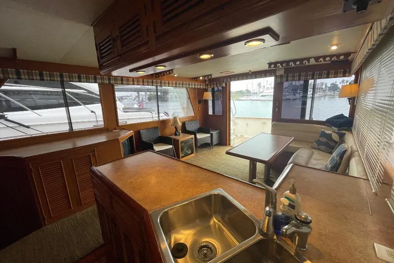 Interior of 1990 Offshore Yachts 55 Pilothouse with cozy seating and large windows.