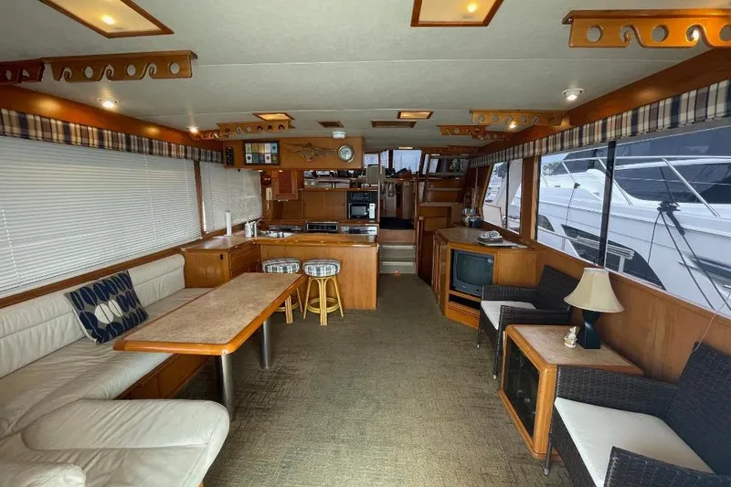 Interior of 1990 Offshore Yachts 55 Pilothouse with cozy seating and wooden furnishings.