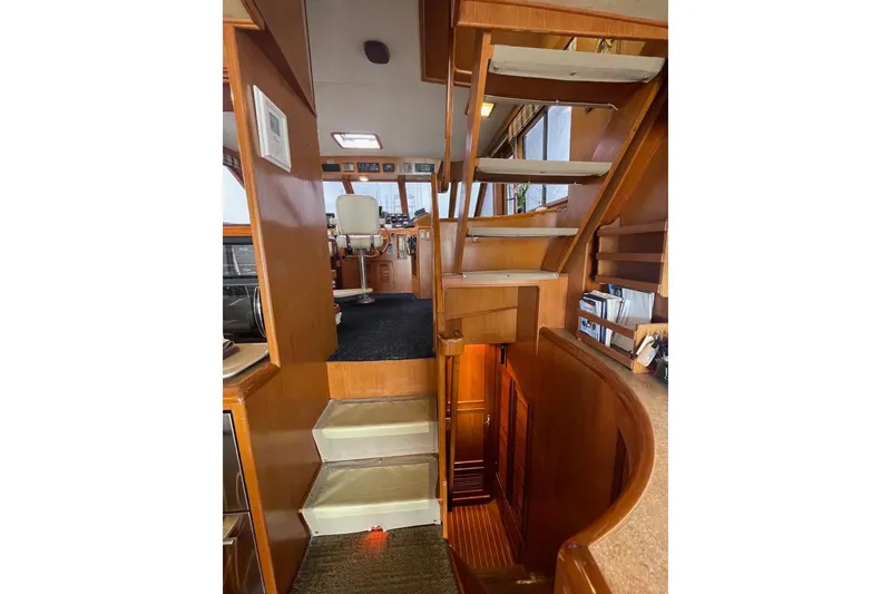 Interior view of 1990 Offshore Yachts 55 Pilothouse, featuring wooden stairs and pilothouse area.
