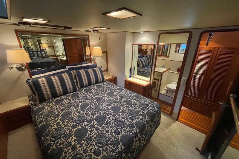 Luxurious bedroom interior of 1990 Offshore Yachts 55 Pilothouse with elegant bedding and ensuite bathroom.