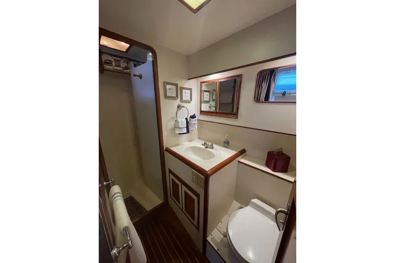 Bathroom interior of 1990 Offshore Yachts 55 Pilothouse, featuring shower, sink, and toilet.