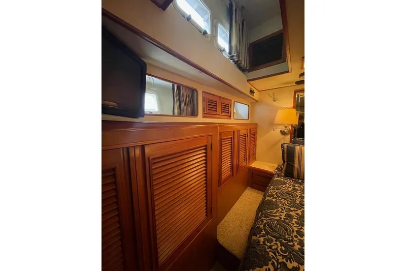 Interior of 1990 Offshore Yachts 55 Pilothouse with wood paneling and cozy furnishings.