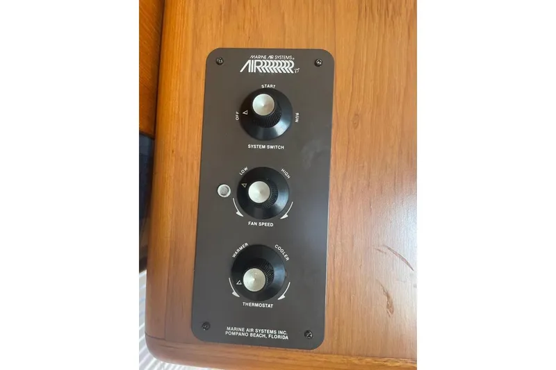 Control panel of a 1990 Offshore Yachts 55 Pilothouse, featuring system switch, fan speed, and thermostat.