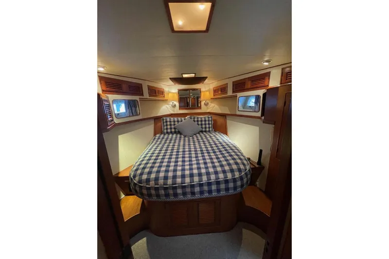 Cozy cabin interior of 1990 Offshore Yachts 55 Pilothouse with checkered bedding.