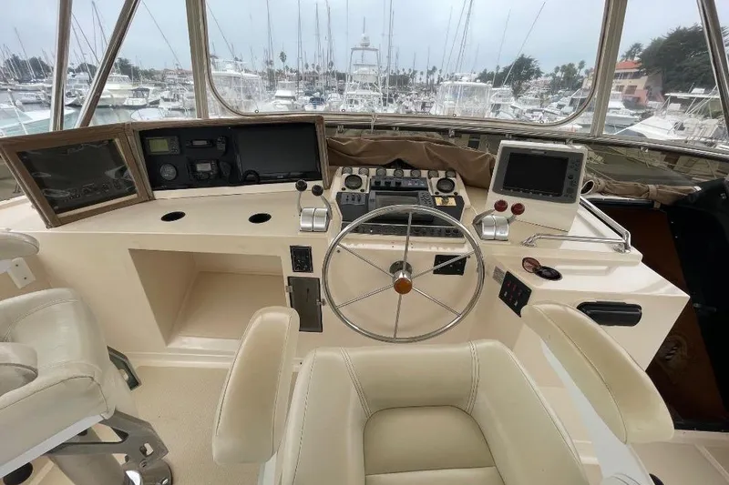Cockpit of 1990 Offshore Yachts 55 Pilothouse with steering wheel and navigation equipment.