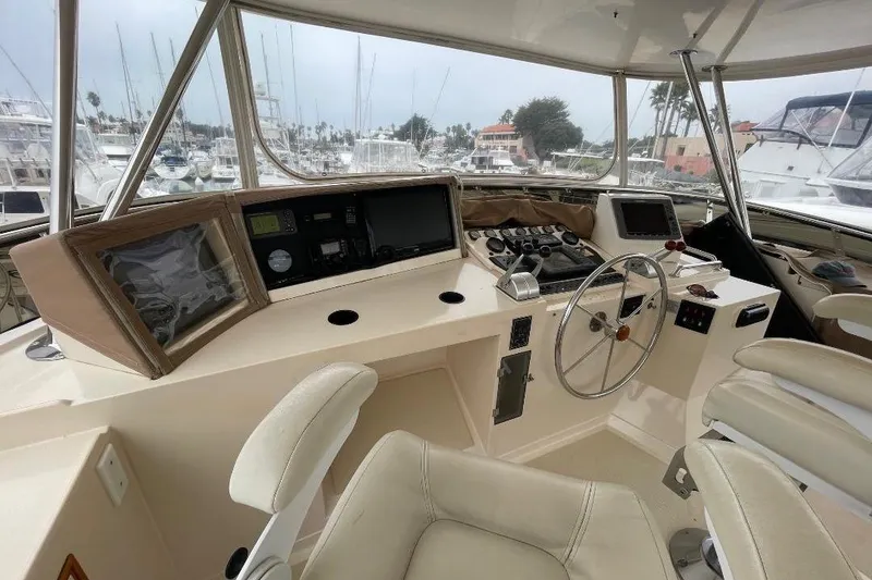 Pilothouse interior of 1990 Offshore Yachts 55, featuring navigation equipment and steering wheel.