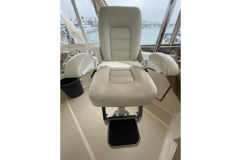 Captain's chair on 1990 Offshore Yachts 55 Pilothouse, featuring plush white upholstery.