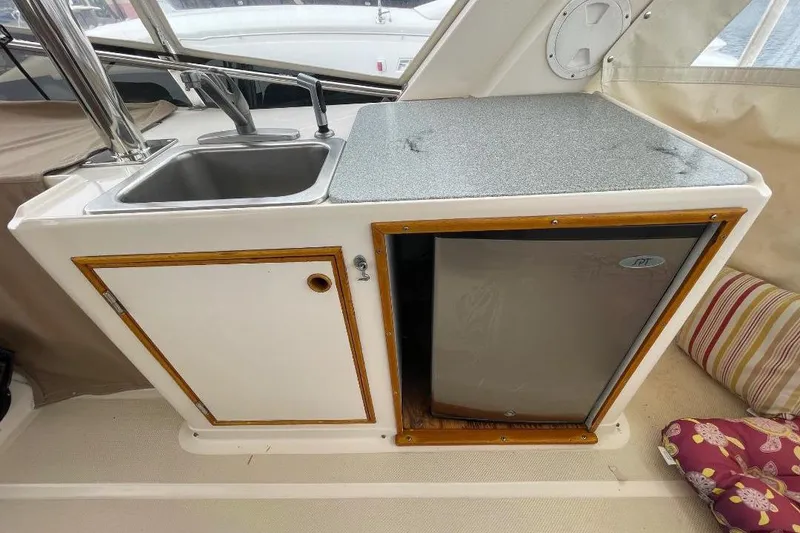 1990 Offshore Yachts 55 Pilothouse kitchenette with sink and mini fridge.