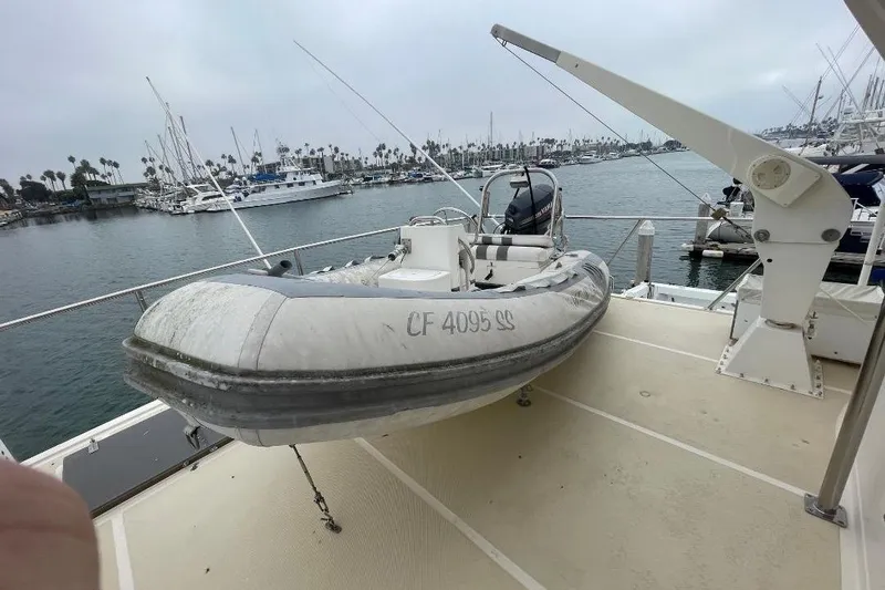 Inflatable boat on deck of 1990 Offshore Yachts 55 Pilothouse, docked at marina.