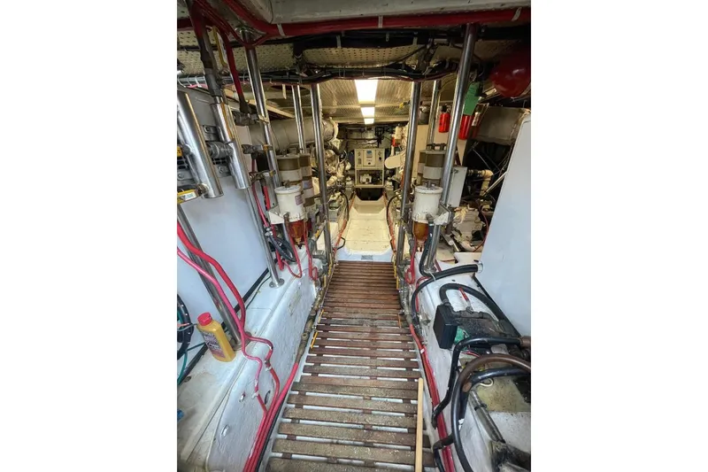Engine room of 1990 Offshore Yachts 55 Pilothouse, showcasing mechanical components and wiring.