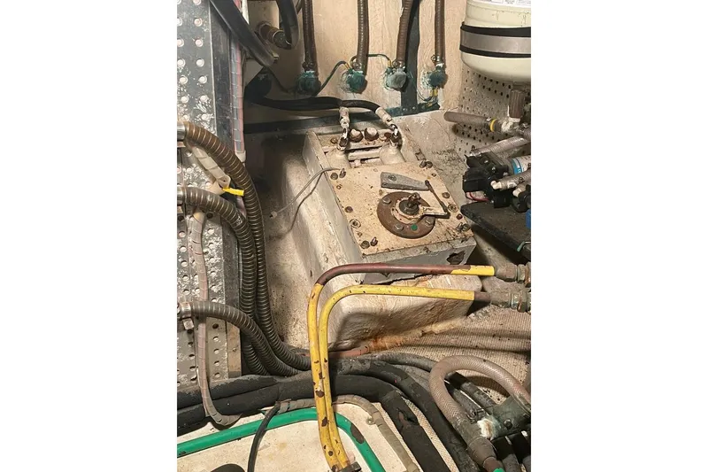 Engine room of 1990 Offshore Yachts 55 Pilothouse with various pipes and components.