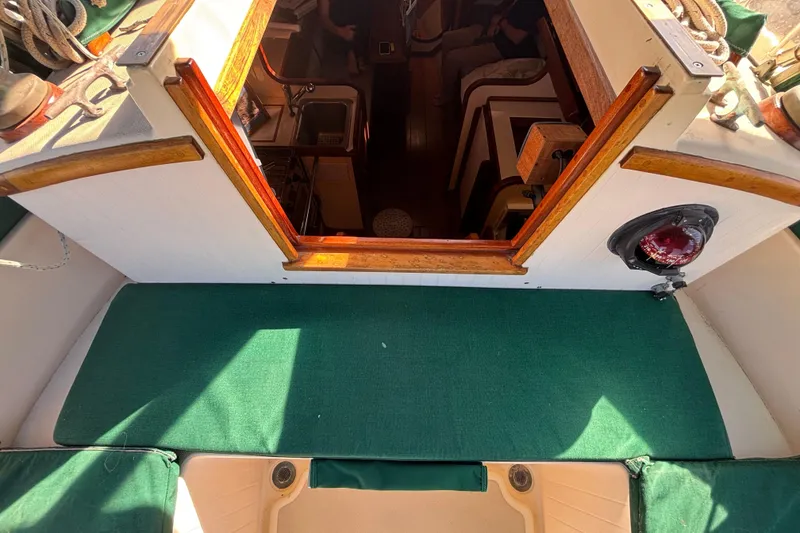 Interior view of 1983 Bristol Channel Cutter 28 sailboat, featuring wooden trim and green upholstery.