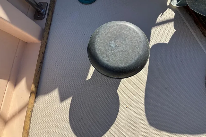 Deck of 1983 Bristol Channel Cutter 28 with a metal object casting a shadow.