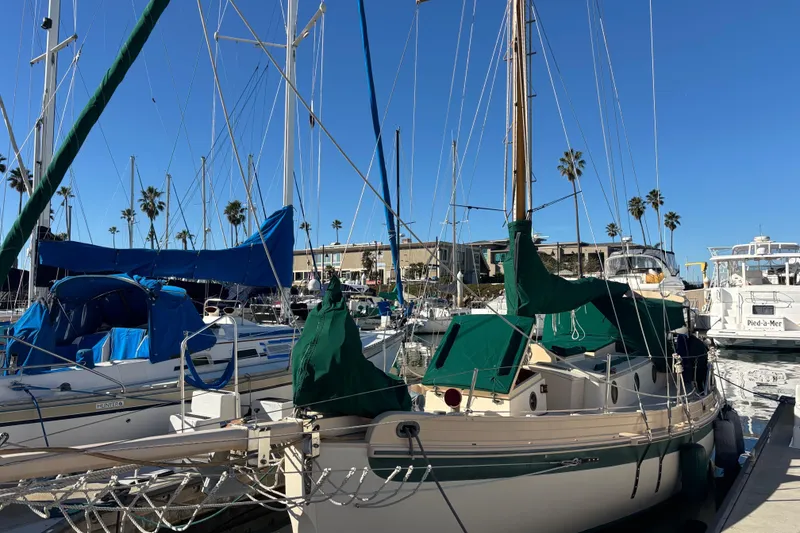 1983 Bristol Channel Cutter 28 sailboat docked in marina with clear blue sky.