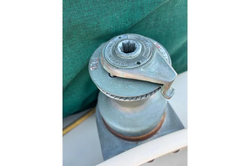 Winch on 1983 Bristol Channel Cutter 28 sailboat, with green canvas background.
