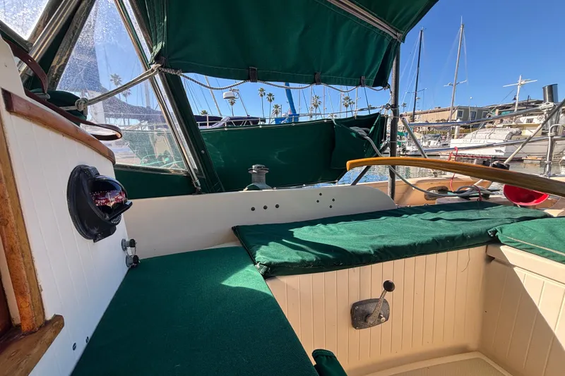 1983 Bristol Channel Cutter 28 cockpit with green canopy, docked in a marina.