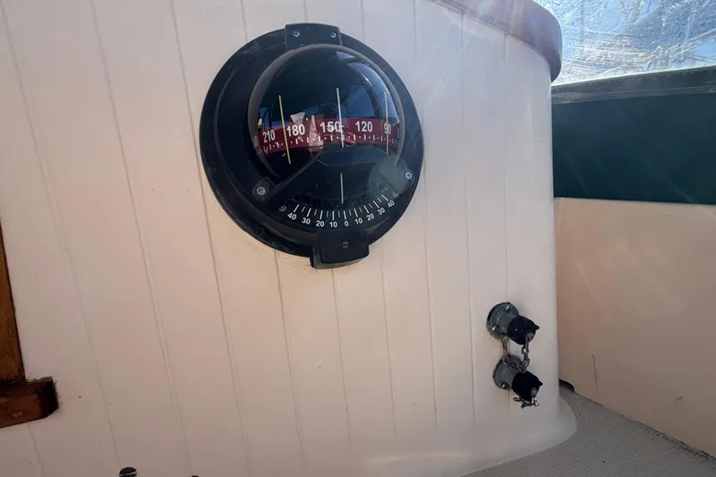 Compass on 1983 Bristol Channel Cutter 28 sailboat, mounted on white panel.