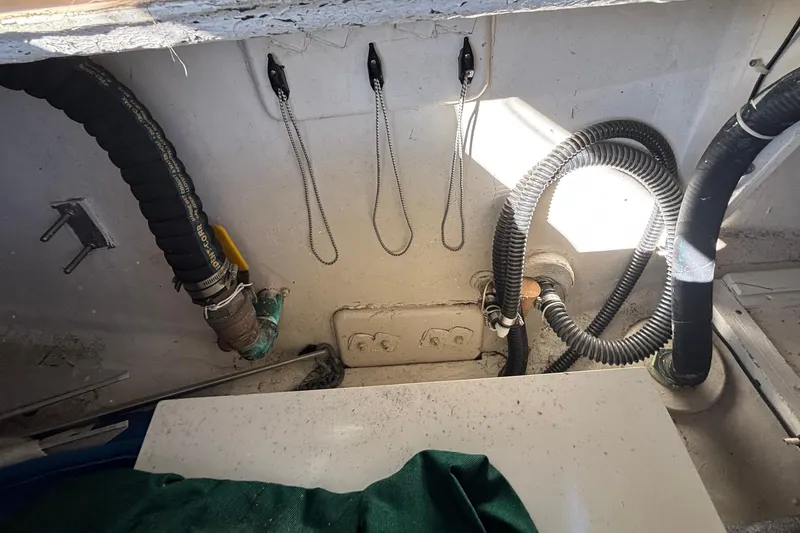 Interior view of a 1983 Bristol Channel Cutter 28, showcasing hoses and fittings.
