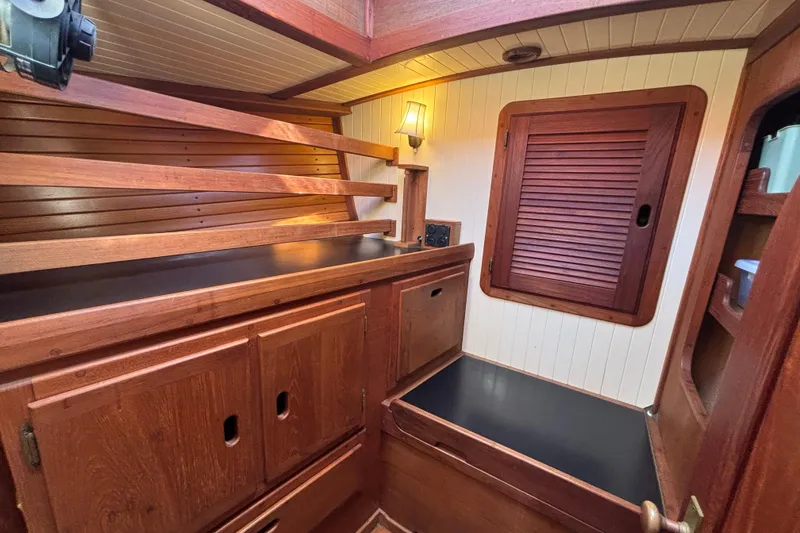 Interior of 1983 Bristol Channel Cutter 28, featuring wooden cabinetry and cozy lighting.