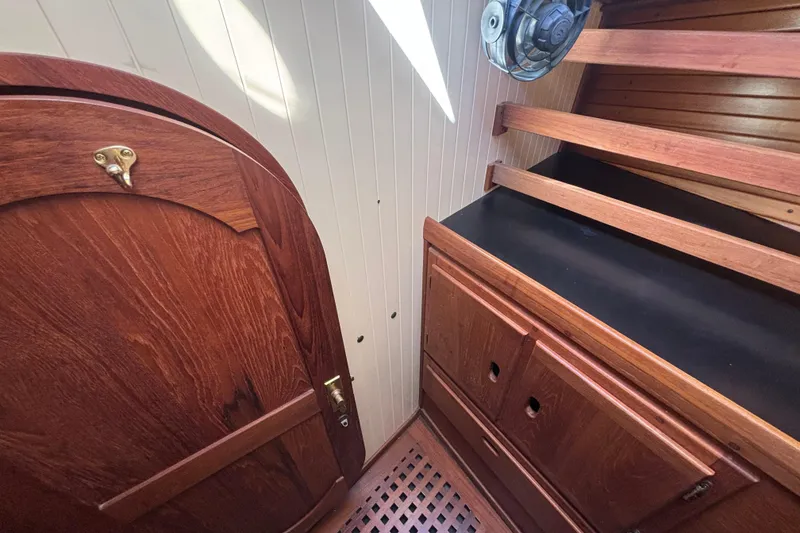 Interior of 1983 Bristol Channel Cutter 28, featuring wooden cabinetry and door.