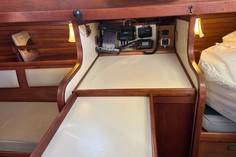Interior of 1983 Bristol Channel Cutter 28 with navigation equipment and cozy seating area.