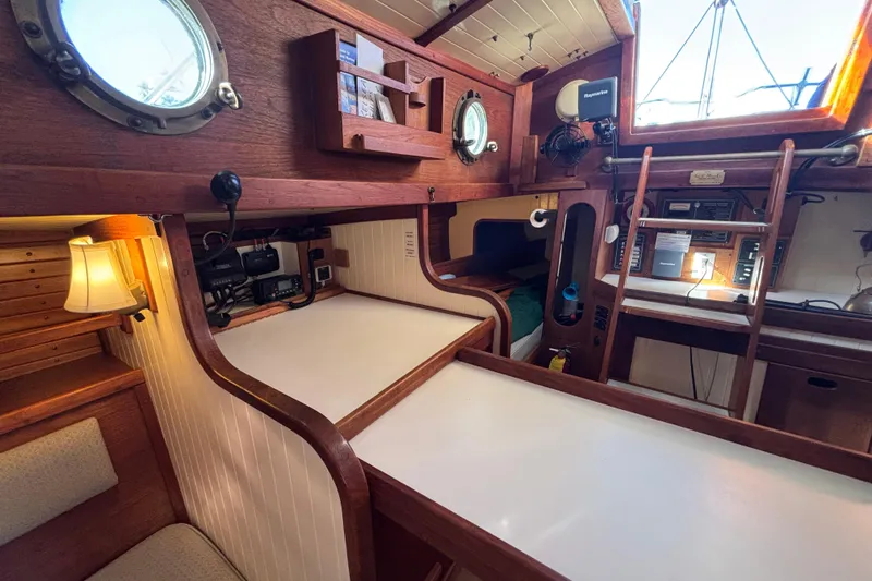 Interior of 1983 Bristol Channel Cutter 28, featuring wood paneling and nautical decor.