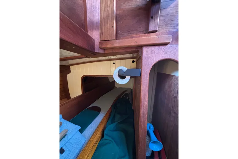 Interior of 1983 Bristol Channel Cutter 28, featuring wooden cabinetry and cozy sleeping area.