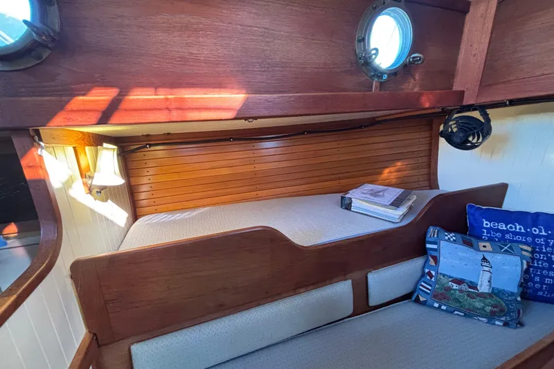 Cozy cabin interior of 1983 Bristol Channel Cutter 28 with nautical decor and wooden finish.