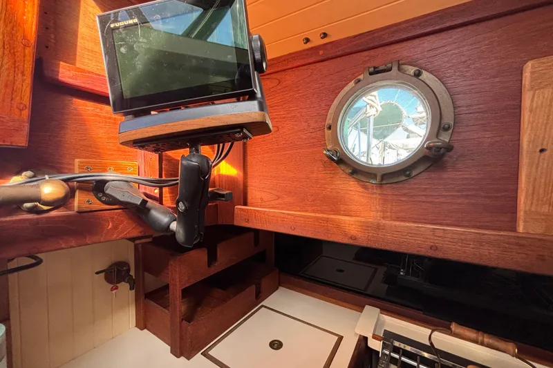 Interior of 1983 Bristol Channel Cutter 28 with navigation equipment and porthole view.