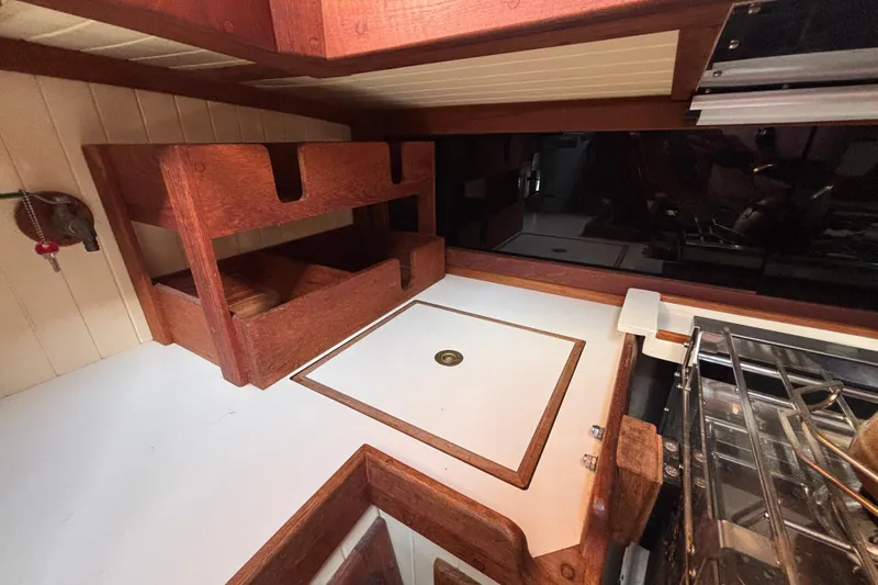 Interior of 1983 Bristol Channel Cutter 28, featuring wooden cabinetry and compact kitchen area.