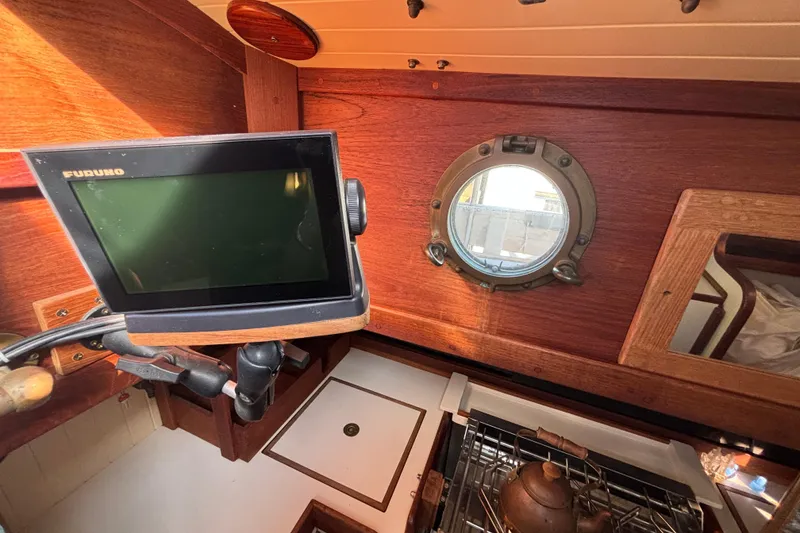 Interior of a 1983 Bristol Channel Cutter 28 with navigation equipment and porthole.