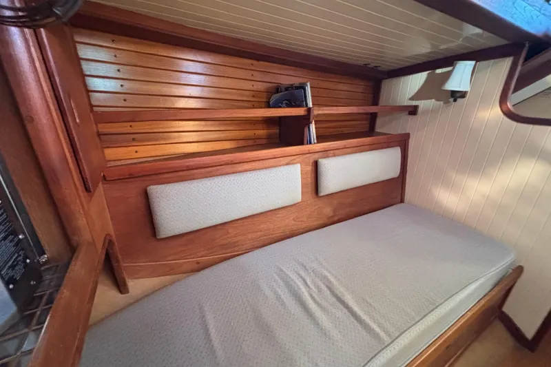 1983 Bristol Channel Cutter 28 interior cabin with wooden paneling and cushioned seating.
