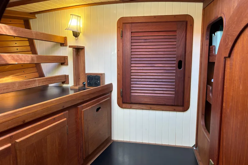 Interior of 1983 Bristol Channel Cutter 28, featuring wooden cabinetry and nautical design.