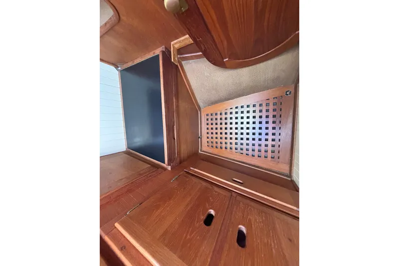 Interior of 1983 Bristol Channel Cutter 28, featuring wooden cabinetry and storage compartments.