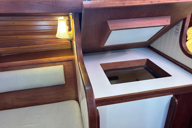 Interior of 1983 Bristol Channel Cutter 28, featuring wooden cabinetry and seating.