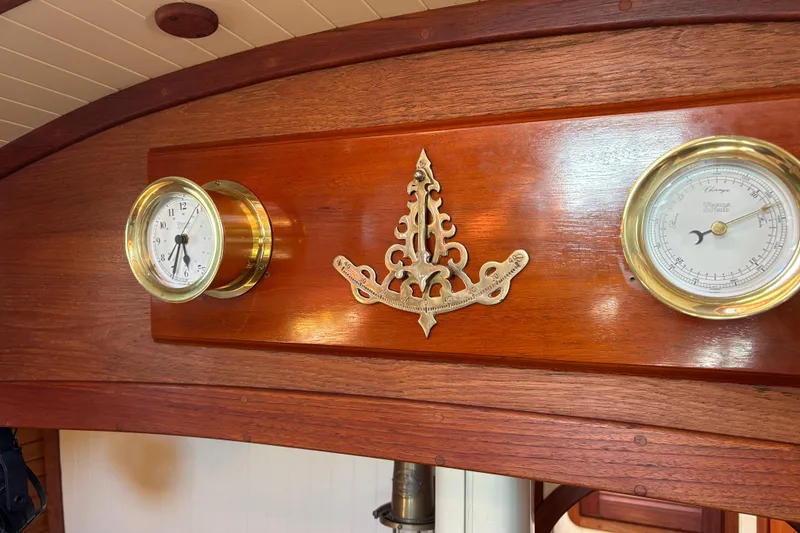 Wooden interior of 1983 Bristol Channel Cutter 28 with brass clock and barometer.