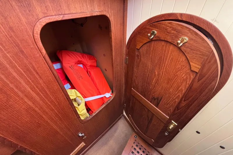 Wooden cabin interior of 1983 Bristol Channel Cutter 28, featuring life jackets in storage.