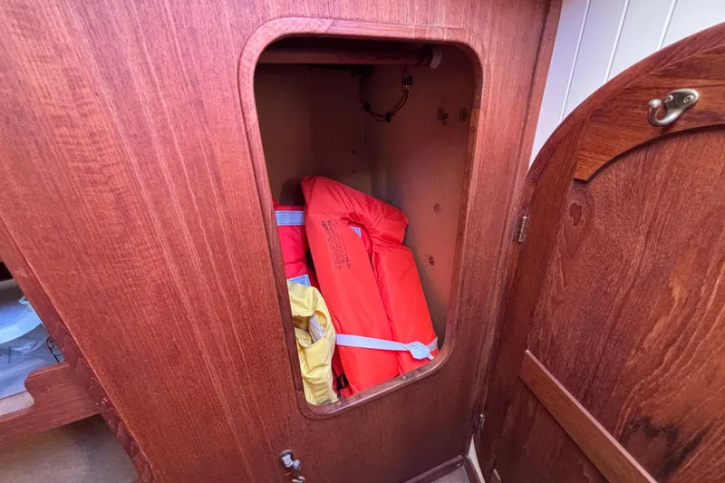 Wooden cabinet on 1983 Bristol Channel Cutter 28, storing life jackets.
