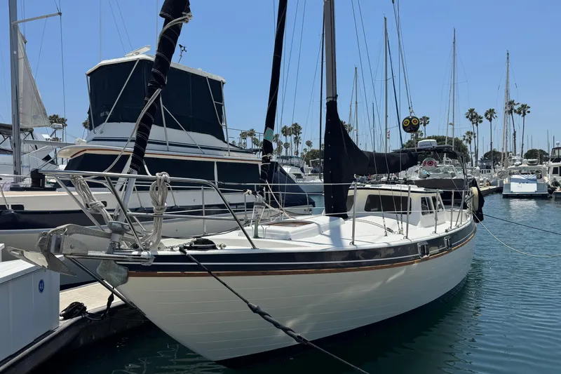 1989 Gulf Pilot House sailboat docked in a marina with clear skies.