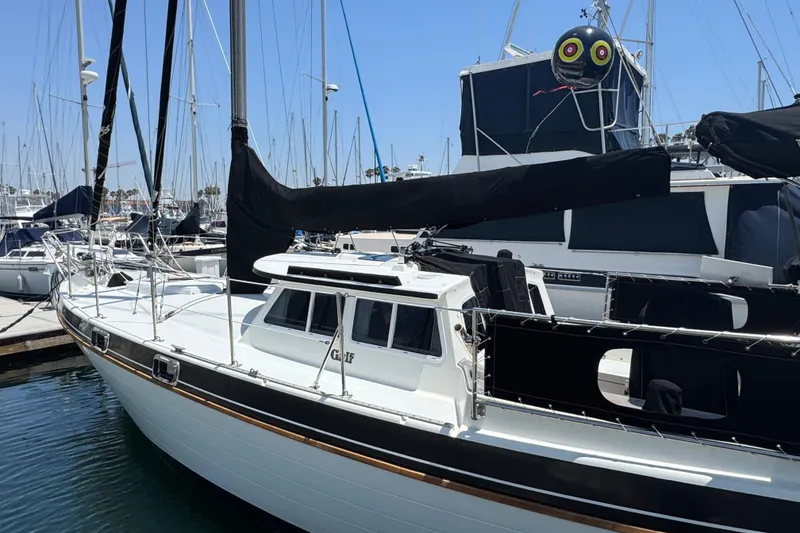 1989 Gulf Pilot House sailboat docked in marina, featuring sleek design and black sail covers.