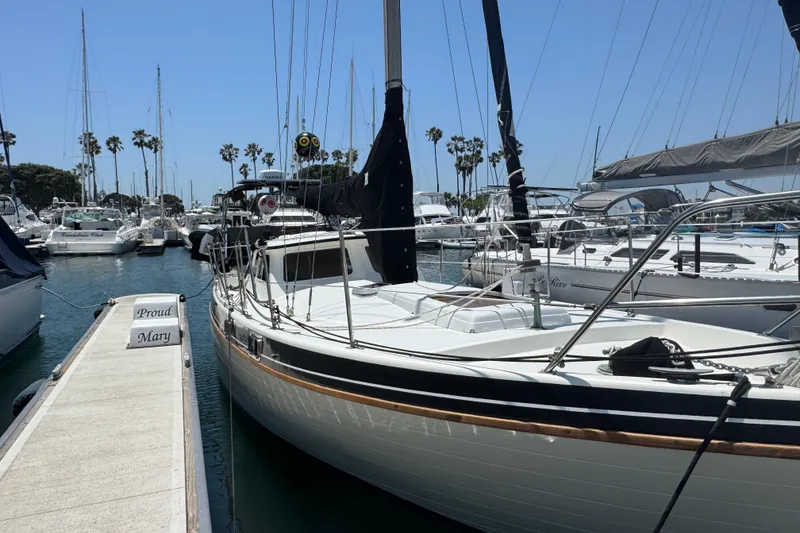 1989 Gulf Pilot House sailboat docked at marina with clear blue sky.