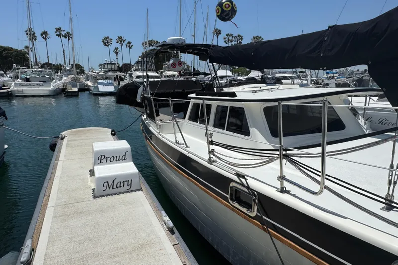 1989 Gulf Pilot House boat docked at marina, labeled "Proud Mary," surrounded by other vessels.