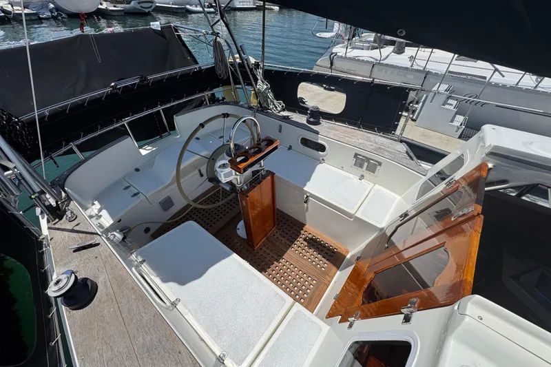 1989 Gulf Pilot House yacht cockpit with steering wheel, wooden accents, and marina view.