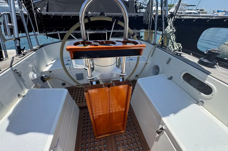 Cockpit of 1989 Gulf Pilot House sailboat with wooden accents and steering wheel.