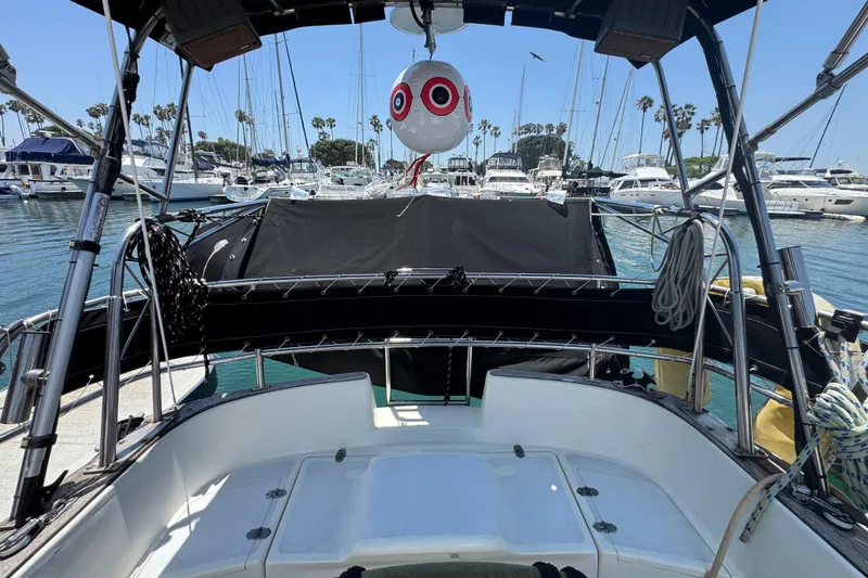 1989 Gulf Pilot House boat cockpit view in marina with sailboats and palm trees.