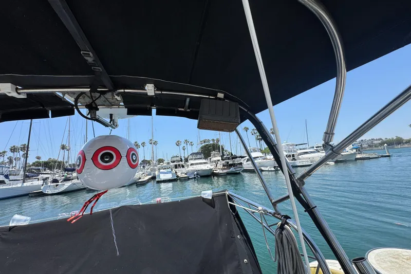 1989 Gulf Pilot House boat in marina, featuring a decorative balloon and clear blue sky.