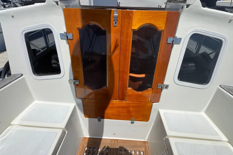 1989 Gulf Pilot House boat cockpit with wooden doors and seating.