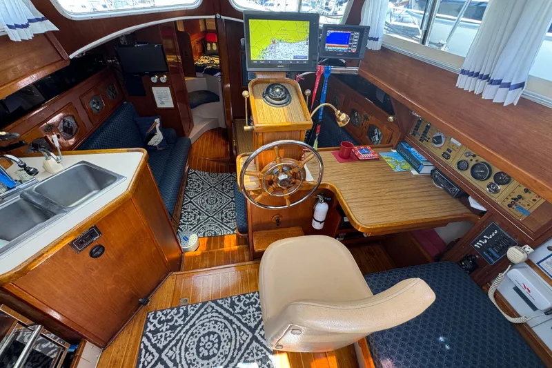 Interior of a 1989 Gulf Pilot House boat with helm, navigation equipment, and cozy seating.