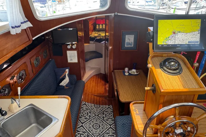 Interior of a 1989 Gulf Pilot House boat with navigation equipment and cozy seating area.